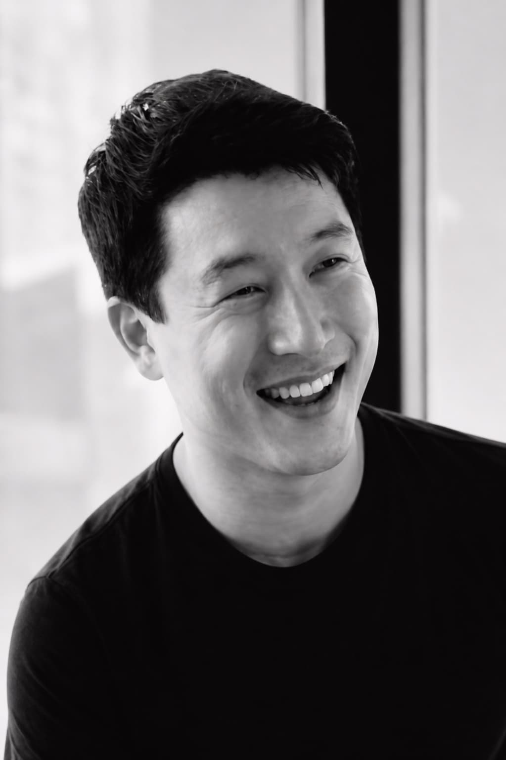 Justin Donovan smiling in a black-and-white portrait
